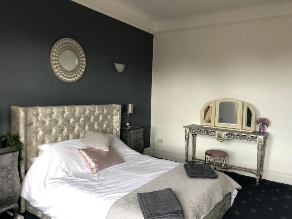 a bedroom with a white bed and a mirror at Apartments at 145 in Southport