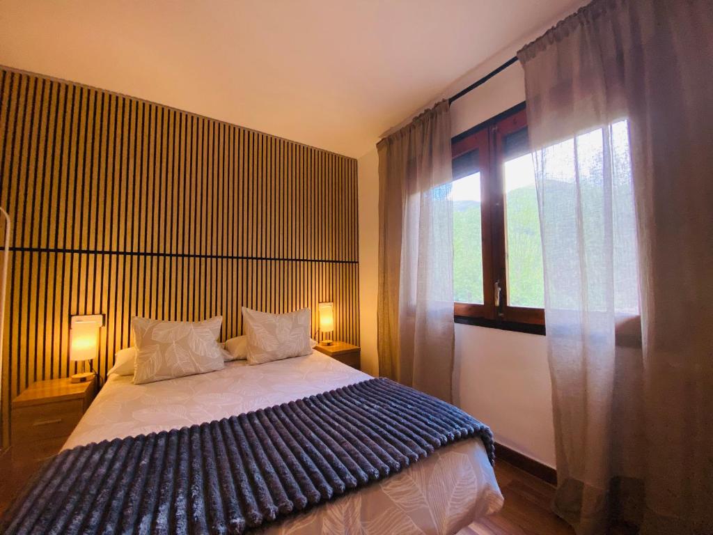 a bedroom with a bed and a large window at Benvinguts a Casa Nostra in El Pont de Suert