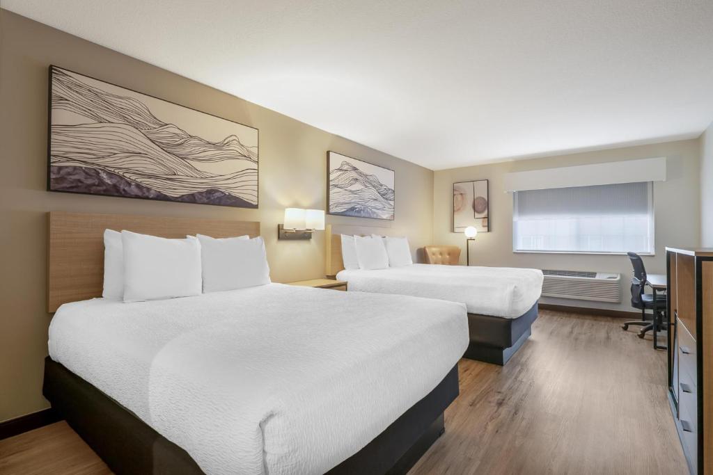 a hotel room with two beds and a desk at Best Western Plus Meridian in Meridian