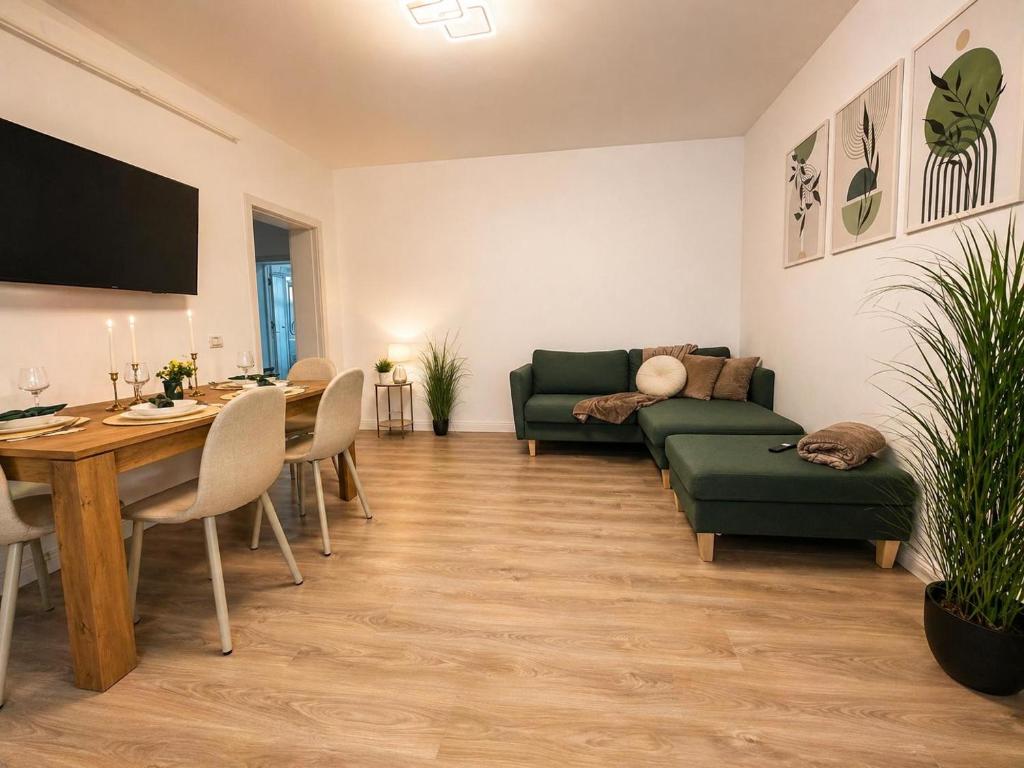 a living room with a green couch and a table at Apartament Nou & Modern în Rădăuți 2 Camere Parcare WiFi in Rădăuţi