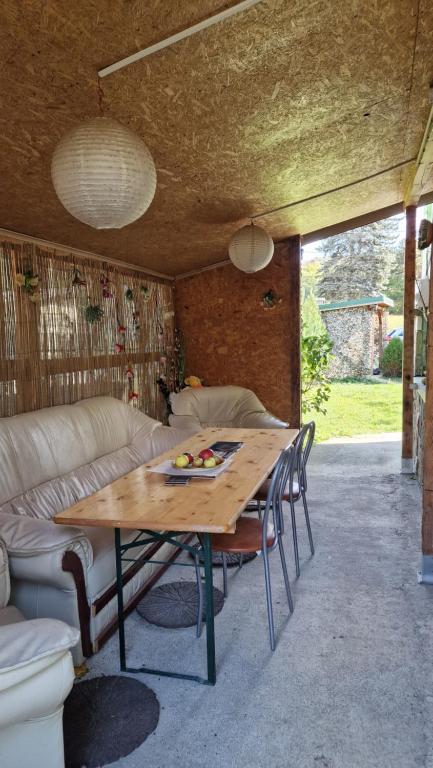 a table and chairs in a living room with a couch at Welcoming home on the corner in Slănic