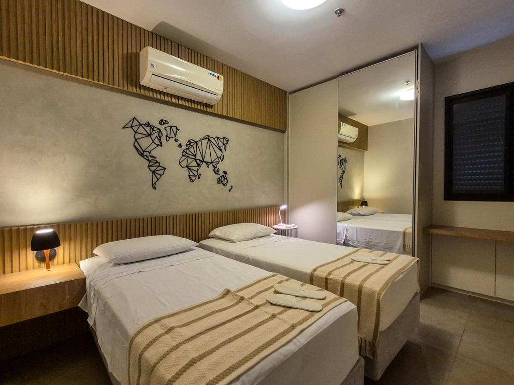 a hotel room with two beds and a mirror at Apartment 13 - Jundiaí in Jundiaí
