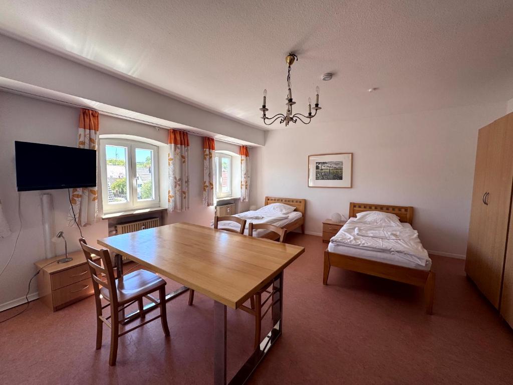 a living room with a dining room table and a bed at W&P Living Zi 5 Bräustüble FeWo 1 2OG l in Buttenwiesen