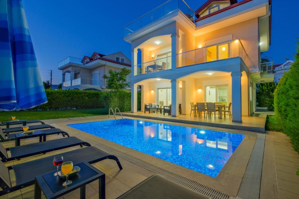 a villa with a swimming pool in front of a house at Villa Calıs 2 in Fethiye
