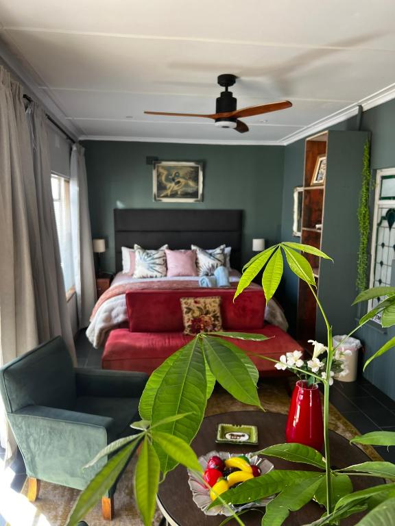 a bedroom with a red bed and a green wall at Greyton Stay in Greyton