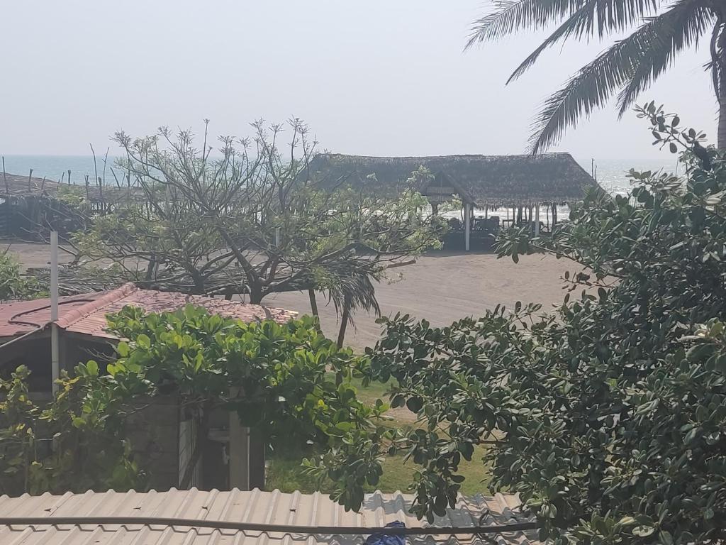a house with a yard with trees and a building at Centro turístico la playitaa in Chachalacas