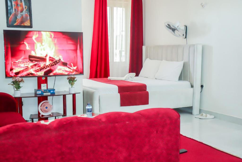 a living room with a bed and a tv at Cozy studio at Kisimani Heights Apartment Mombasa in Mombasa