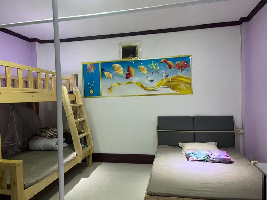 a bedroom with two bunk beds and a ladder at FUBON World Guesthouse in Ban Nongpapao