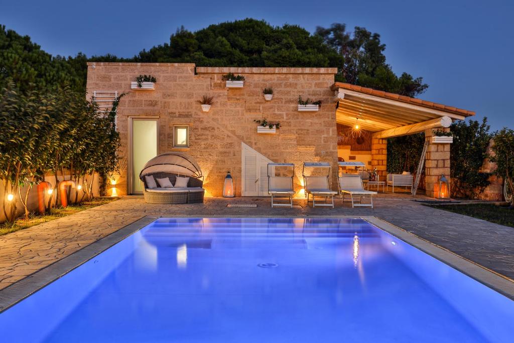 a swimming pool in front of a house at Villa con piscina Seychelles del Salento in Marina di Pescoluse