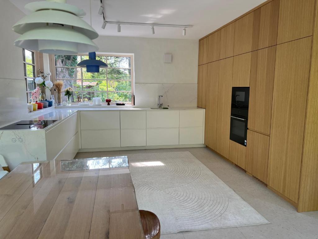 a kitchen with white cabinets and a table and a window at Fészek Villa in Balatonszemes