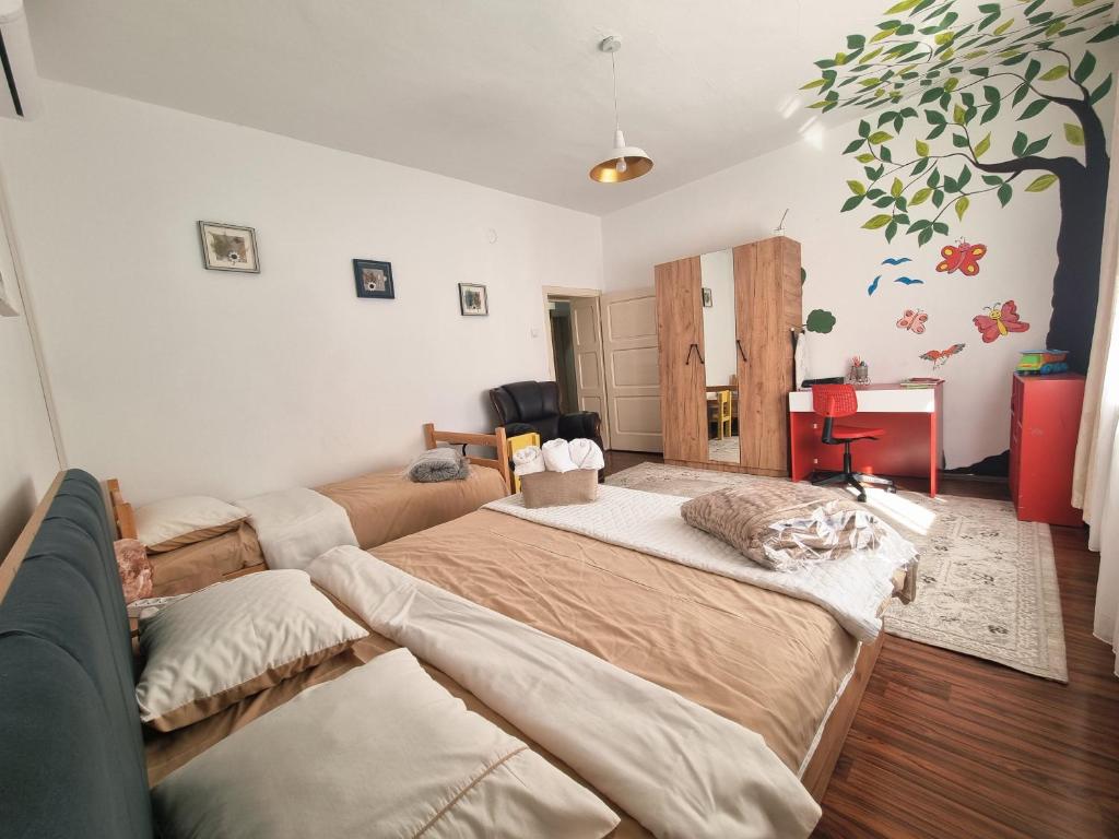 a bedroom with two beds and a couch at Artisan Center Apartment Peja in Peje
