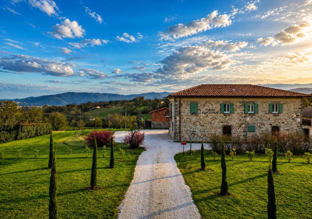 a stone house in a field with a gravel road at Agriturismo Podere Sant' Agnese - Suite Apartment in Bibbiena