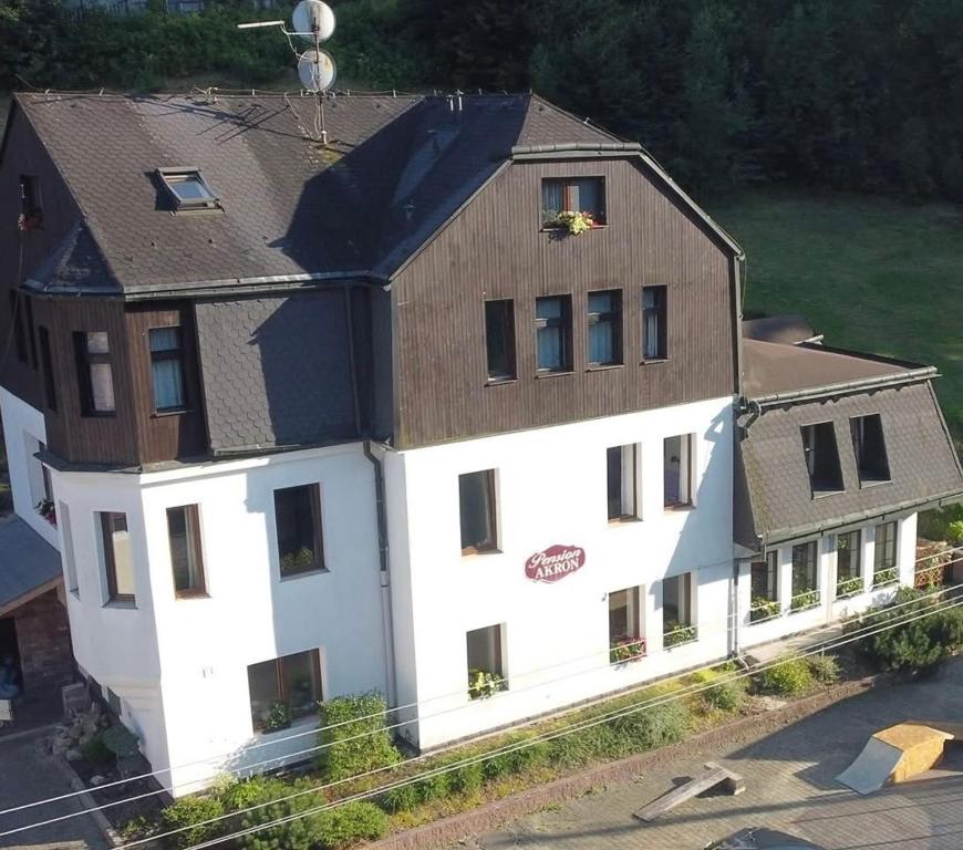 a large white building with a brown roof at Penzion Akron in Tanvald