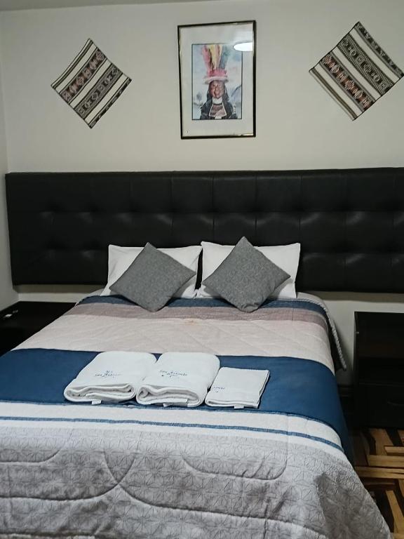 a bedroom with a bed with two towels on it at HOTEL San Antonio in Puno