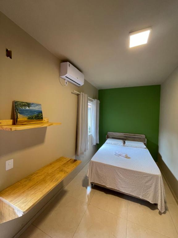 a bedroom with a bed and a green wall at Casa Dona Vilma in Barreirinhas