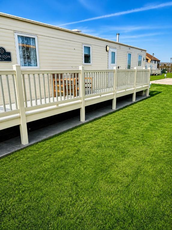a white fence in front of a house at Beachside 3 Bed Caravan with Deck & Outside Seating Mablethorpe in Mablethorpe