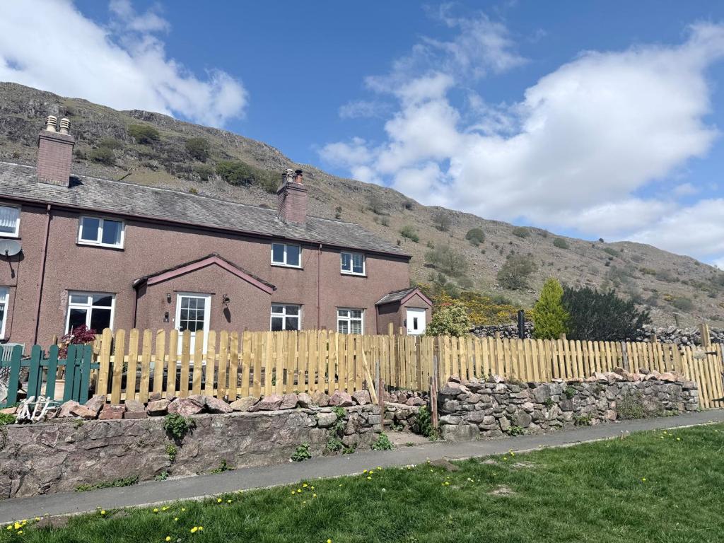 a house with a fence and a hill in the background at Dakota in Holmrook