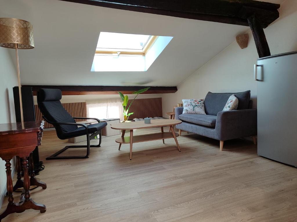 a living room with a couch and a table at La Mansarde étoilée in Saint-Marcellin
