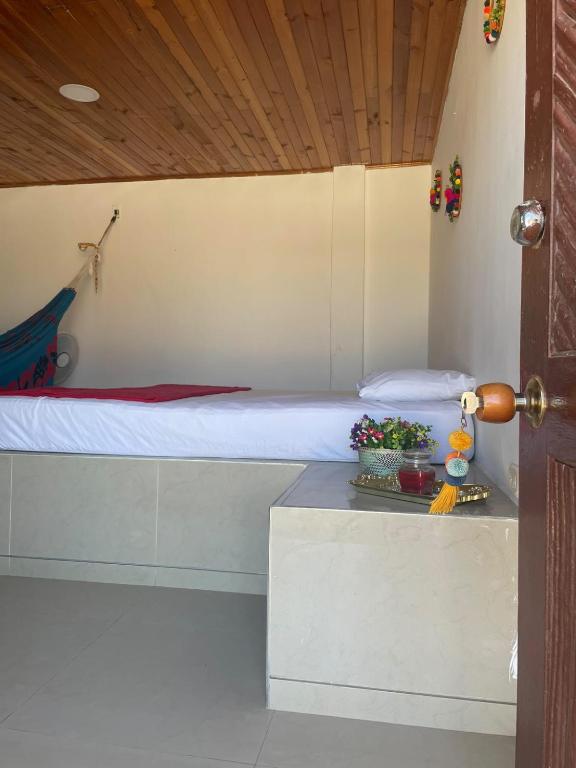 a bedroom with a bed and a table with flowers at Hotel Cabo Royal in Cabo de la Vela