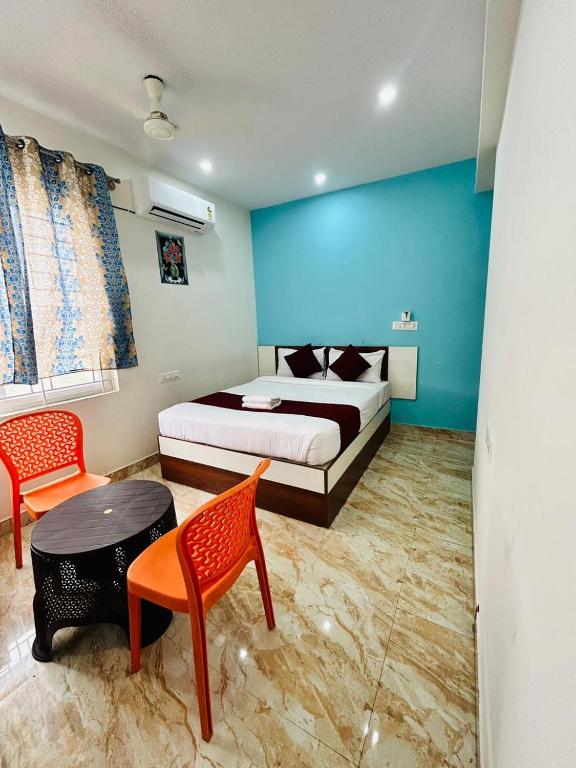 a bedroom with a bed and a table and chairs at S K Comforts in Bangalore