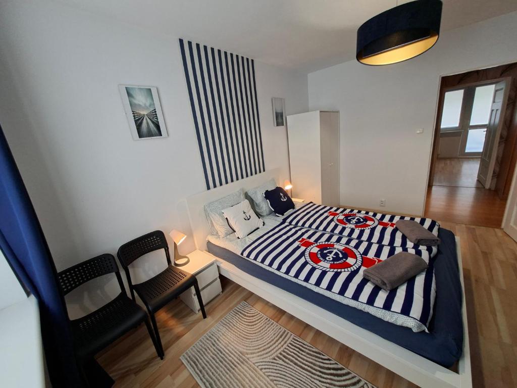 a bedroom with a bed and a chair in it at Apartament w Centrum III in Ustka