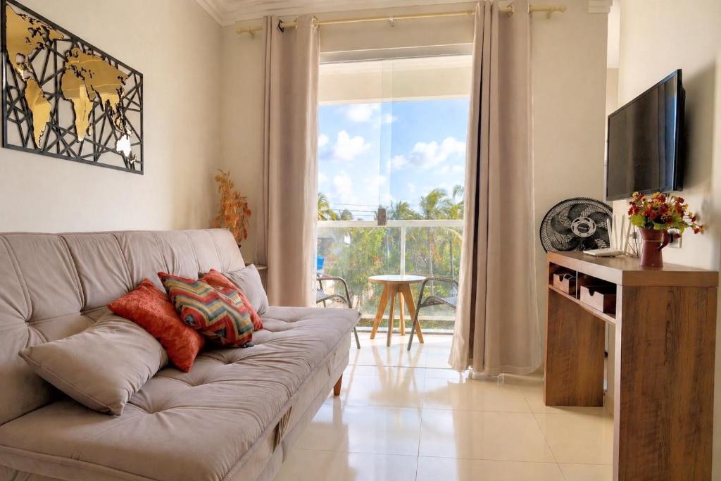 a living room with a couch and a television at Top-Flat @ Bella Maré in Maragogi