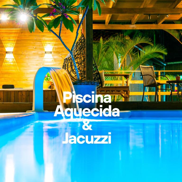 a pool at a resort with a sign that says pizza analgesia and jac at Pousada Gauleses - Refugio de Charme na Praia do Rosa by La Vem Férias in Praia do Rosa