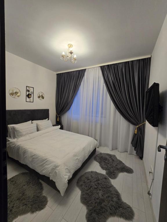 a bedroom with a bed with furry pillows and curtains at DeLux Apartment -Militari Residence Rosu Chiajna in Dudu