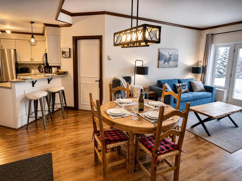 a kitchen and living room with a table and chairs at Superb ski inout - Ask about summer pool access! in Mont-Tremblant