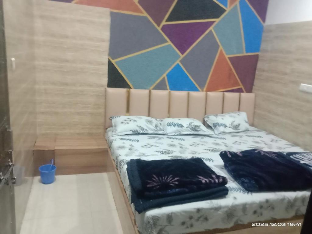 a bedroom with a bed and a colorful wall at Hotel Murlidhar in Chikāra