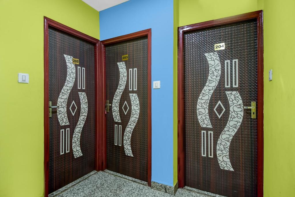 a pair of doors in a room with graffiti on them at Super Hotel O Acropolis Mall Kolkata Formerly The Orchid Residency in Kolkata