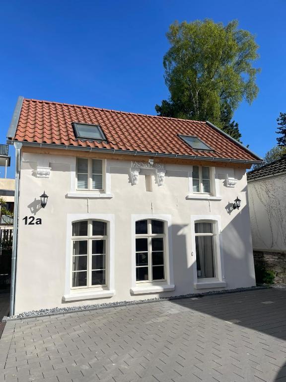 a white house with a red roof at TINY TEUTO HOUSE- Die alte Schusterei in Detmold