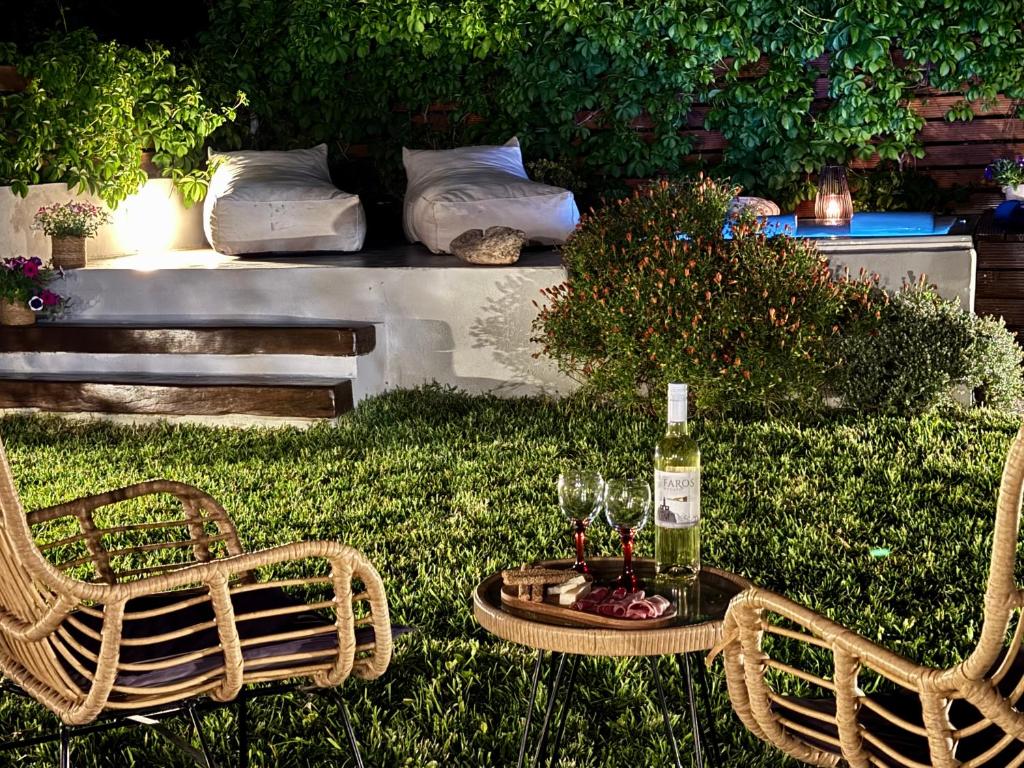 a table with a bottle of wine and two chairs at Averto House Lefkada in Lefkada