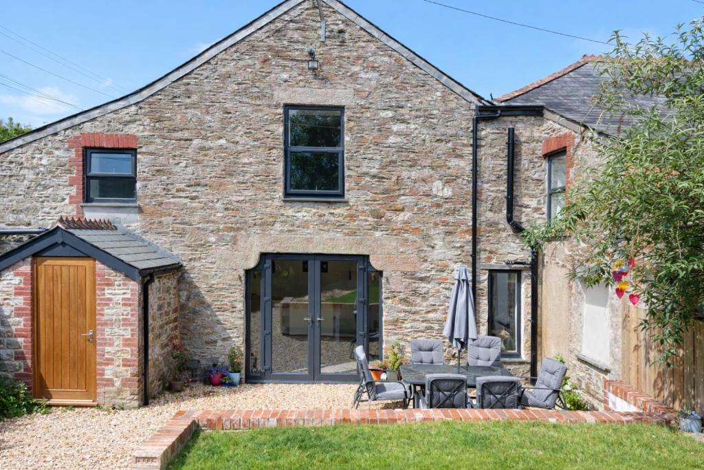 an extension to a brick house with a patio at Swallows Rest Cottage - 3 Bedrooms - Nr Looe in Looe
