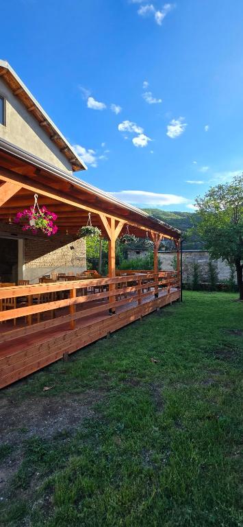 a wooden pavilion on the side of a house at Sekretet e Luginës Restaurant - Hostel - Camping in Vau i Dejës