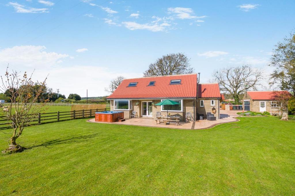 a house with a red roof on a green field at 3 Bed in Ebberston oc-s35053 in Ebberston