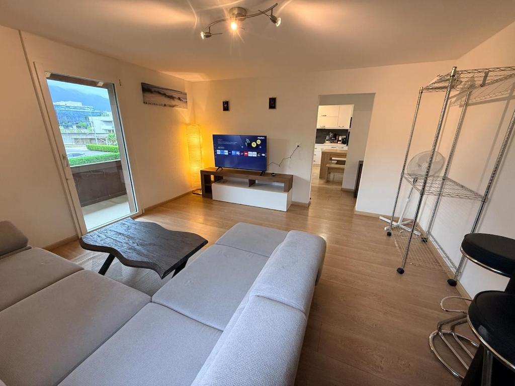 a living room with a couch and a tv at Ferienwohnung Winterzeit Thunersee&Mountainview in Thun