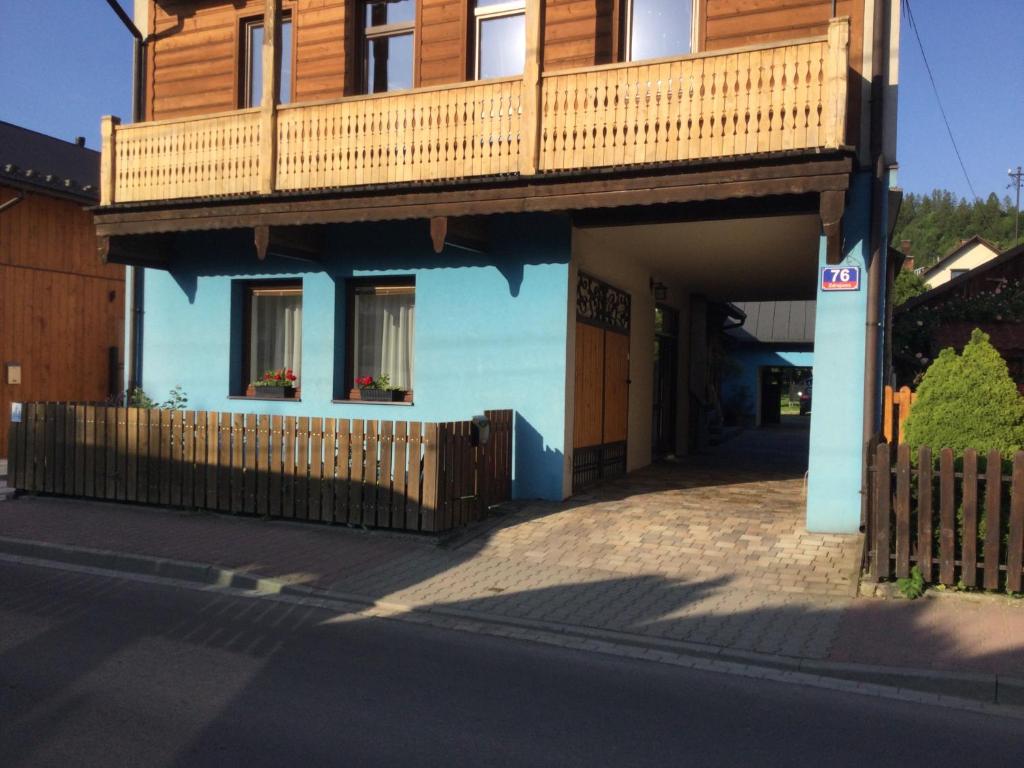 a blue house with a balcony on top of it at Willa Trzy Podkowy in Krościenko