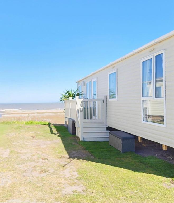 a house on the beach next to the ocean at 9 Sea View Kessingland Beach Parkdean Resorts MIN 3 NIGHT STAY in Kessingland