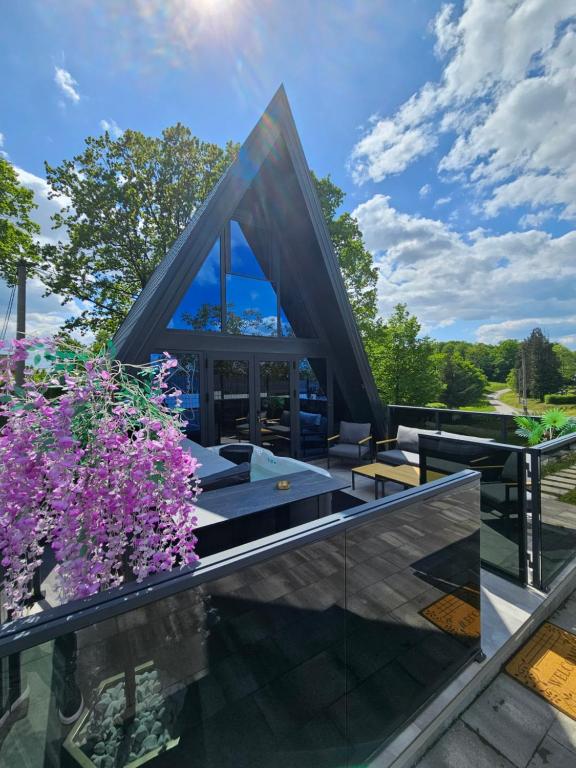 a house with a glass roof with purple flowers at Charda Guesthouse in Laktaši