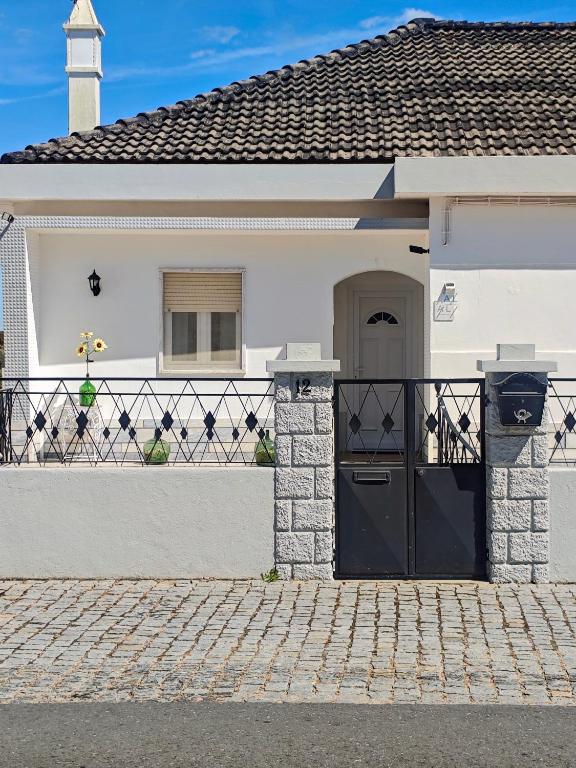 a white house with a gate and a driveway at Vivenda Becho in Alpalhão