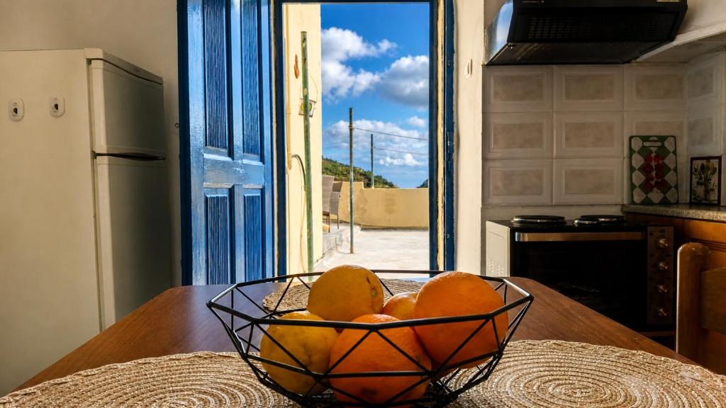 a bowl of oranges on a table in a kitchen at Saint George Terrace House in Chios