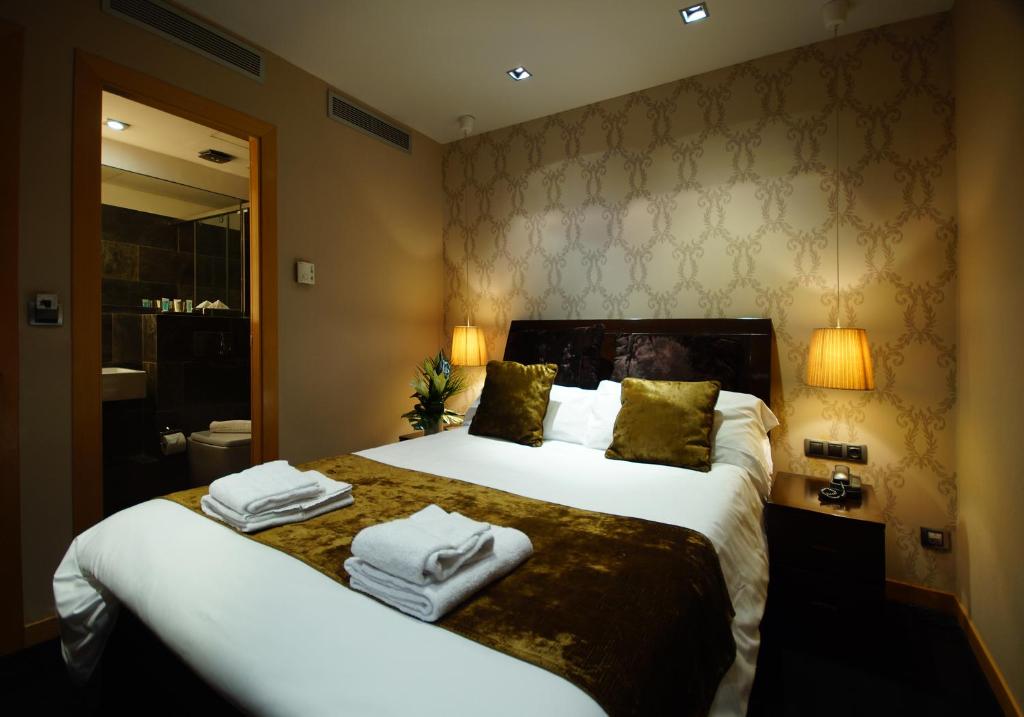 een hotelkamer met een groot bed met handdoeken erop bij Casa Boutique Barcelona in Barcelona