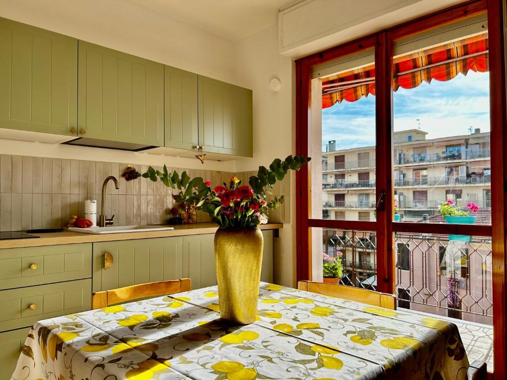 a kitchen with a table with a vase of flowers on it at Casa Marysol in Ventimiglia