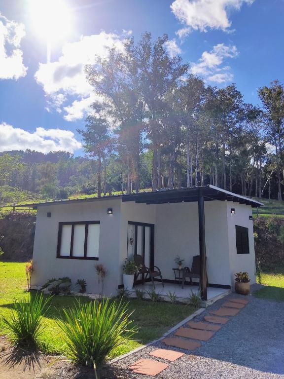 a small white house with a patio in a field at Casa do Bem Estar Picada Café in Picada Cafe
