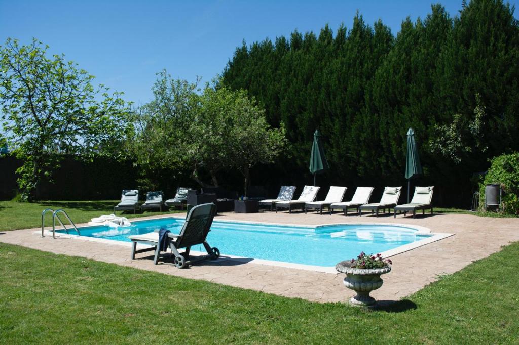a swimming pool with lounge chairs and a table at Casa rural osvilares in Santiago de Compostela