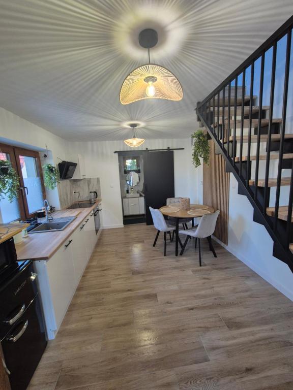 a kitchen and dining room with a table and a staircase at Apartament Królówka in Nowy Wiśnicz