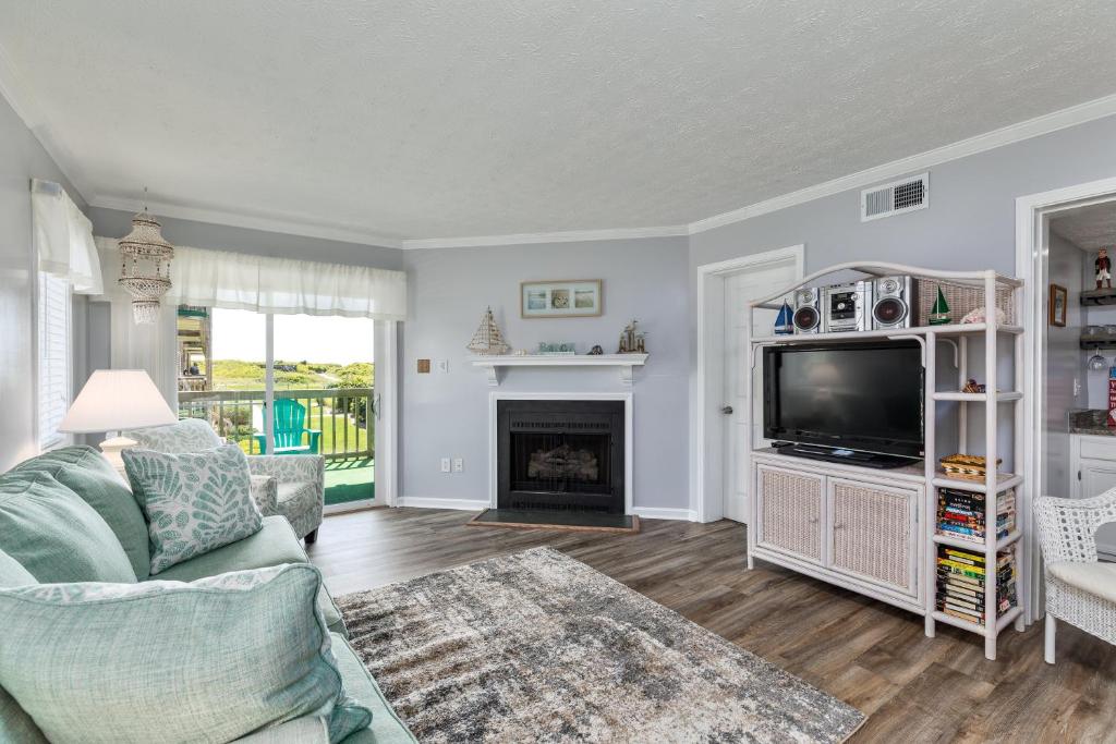 a living room with a tv and a fireplace at 4104 - Sever's Hideaway in Duck