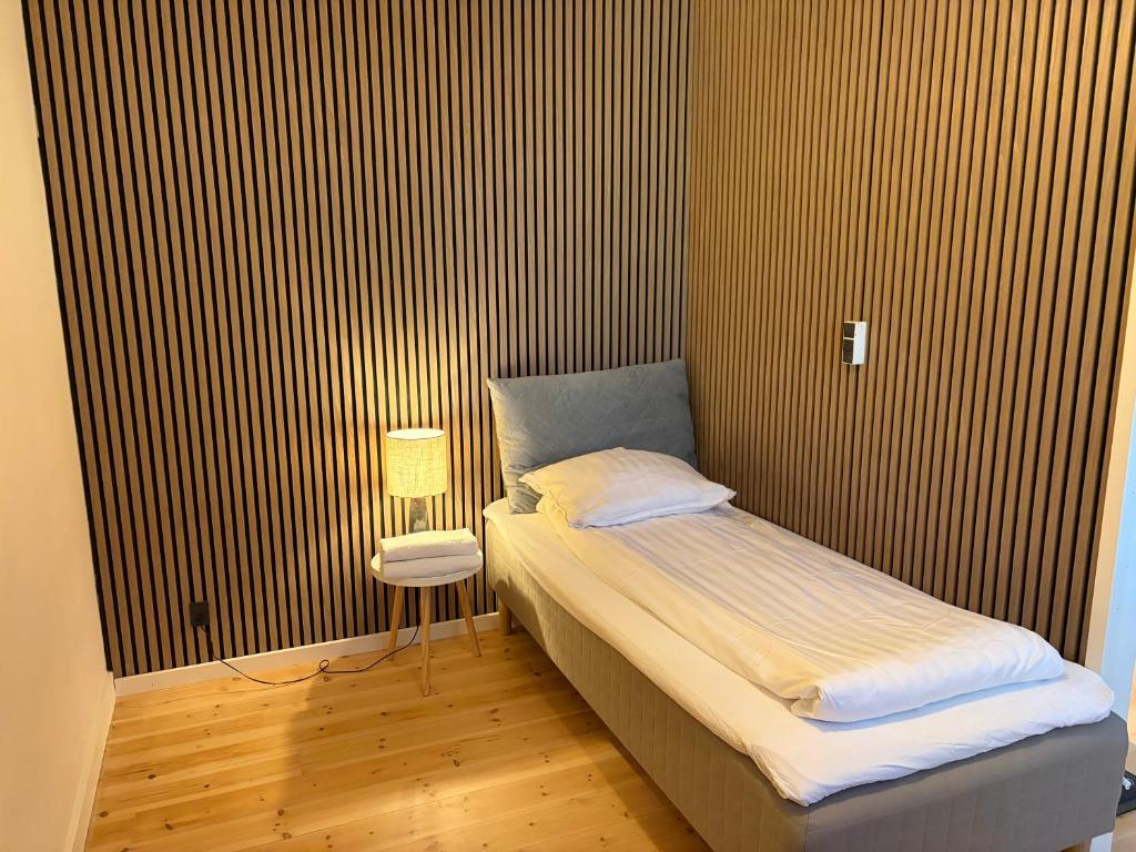 a small bedroom with a bed and a chair at Lille Skovgaarden ved parken med gratis parkering in Randers