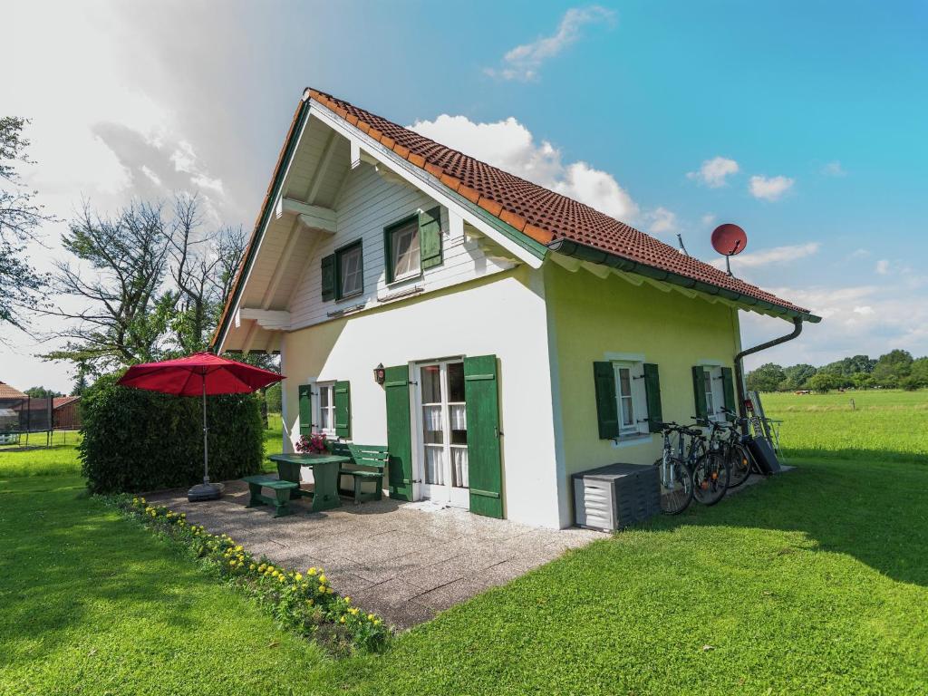 ein kleines Häuschen mit einem Picknicktisch und einem Sonnenschirm in der Unterkunft Alluring Holiday Home in Ubersee with Whirlpool in Übersee